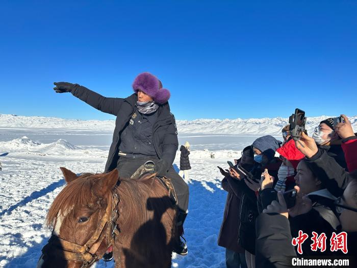 叶尔达那向“追着雪花看新疆”媒体团的记者们介绍自己的马队。唐娟 摄