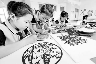 山东省青岛市龙山中心小学的学生在学习剪纸。梁孝鹏摄/光明图片