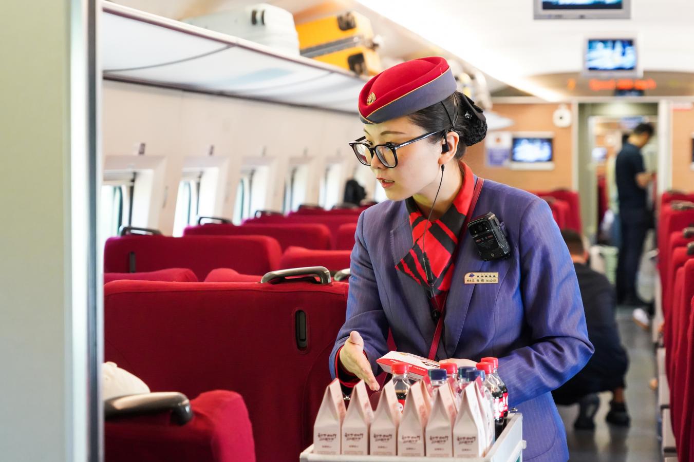 (7) 2024年5月1日，西安北至上海虹桥G1918次列车，西安客运段列车乘务员为旅客提供餐点服务。（刘翔 摄）