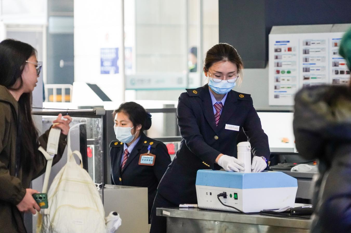 (1) 2024年5月1日，西安北站，铁路安检人员检测水杯内液体保障假期旅客出行平安。（刘翔 摄）