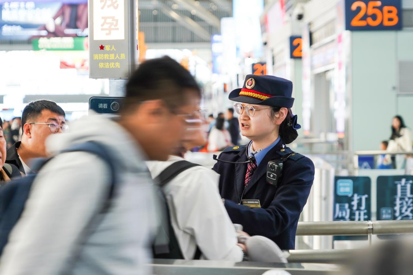 (3) 2024年5月1日，西安北站，铁路客运工作人员引导旅客快速有序通过验票闸机进站乘车。（刘翔 摄）