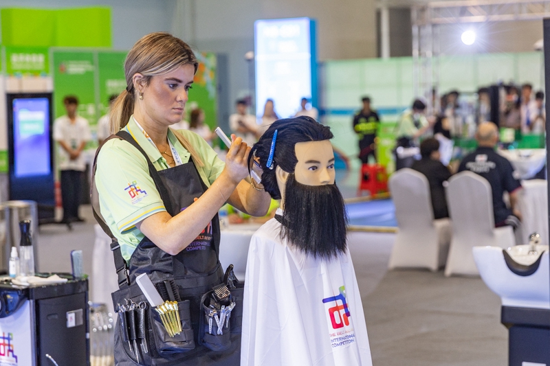 6月24日,在重庆国际博览中心举行的第二届“一带一路”国际技能大赛现场,参赛选手在参加美发项目比赛。