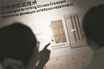 在北京外国语大学世界语言博物馆“汉字的实现技术”展板前,观众正在观看中国古代简牍。新华社记者 陈钟昊摄