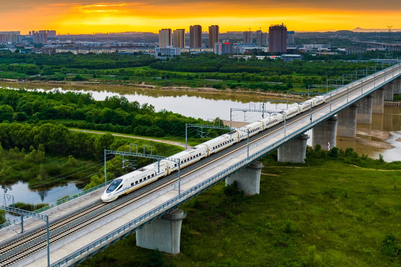 (3) 2024年8月3日，陕西西安，一趟“和谐号”动车组列车傍晚从银西高铁渭河特大桥飞驰而过。（刘翔 摄）