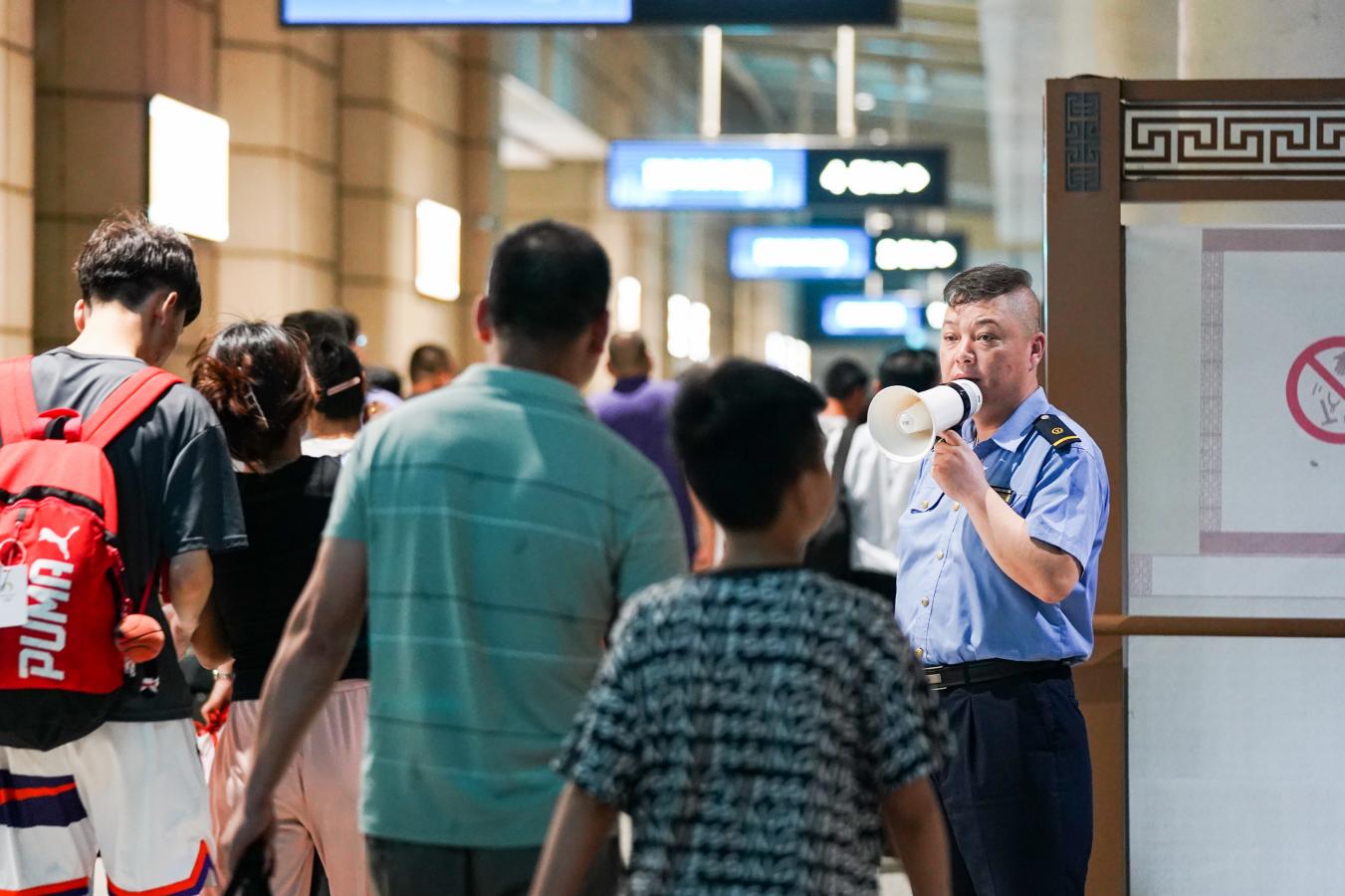 (9) 2024年8月5日，西安火车站，铁路工作人员组织旅客有序乘车。（刘翔 摄）
