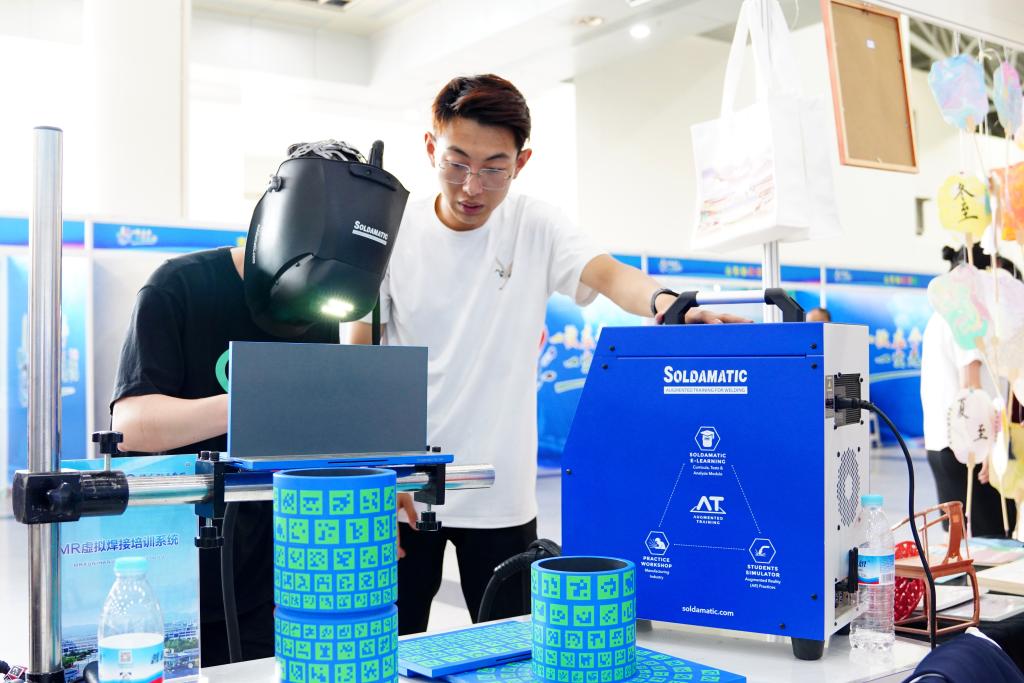5月11日,在济南舜耕国际会展中心济南职业学院展台,一位同学在体验MR虚拟焊接培训系统。新华社记者 郭绪雷 摄