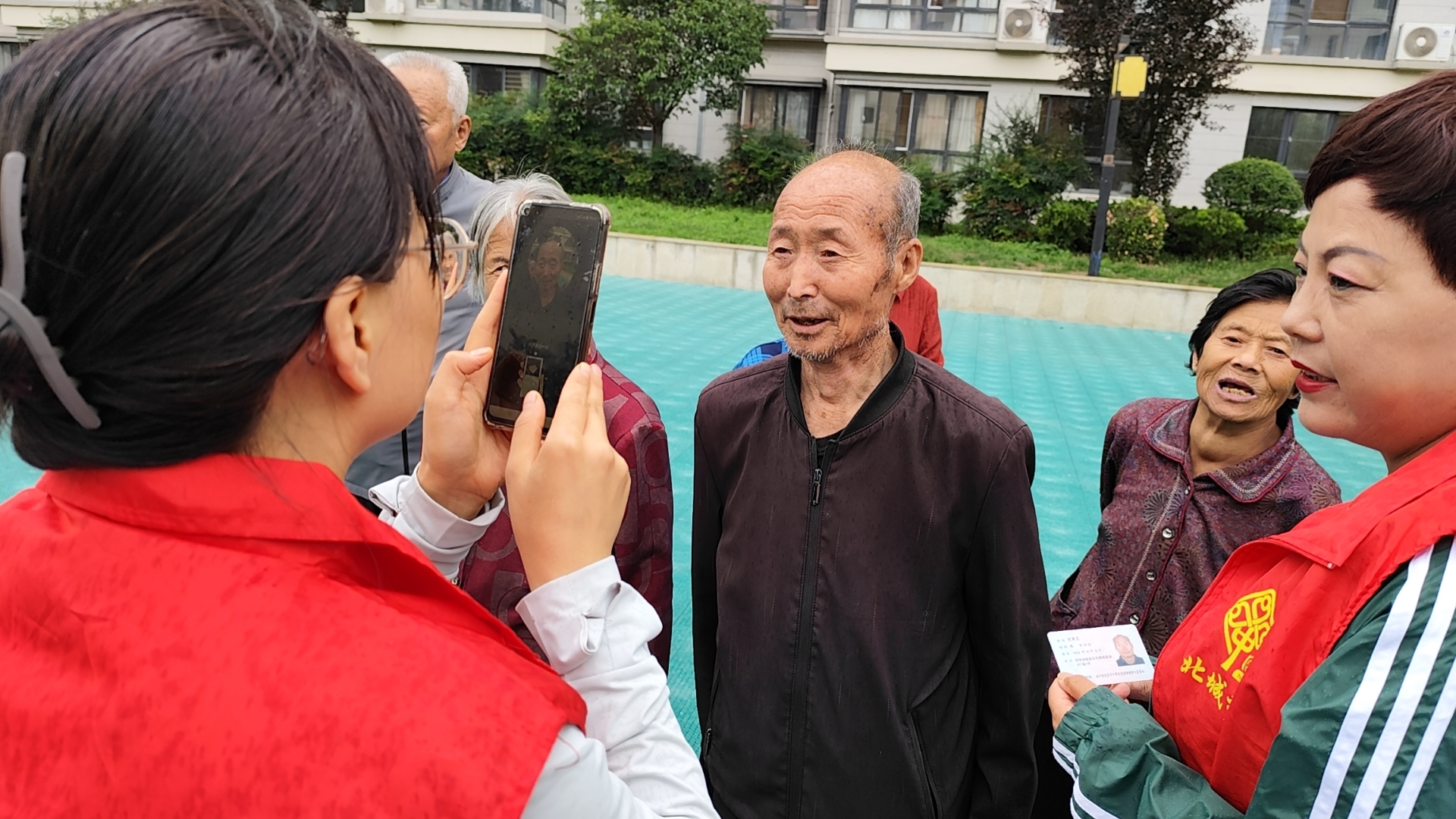 社区工作人员为居民进行养老保险年审