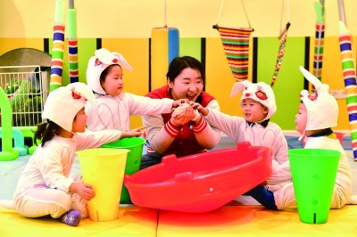 在山东省日照市东港区一家托幼园,老师陪伴孩子做游戏。新华社发