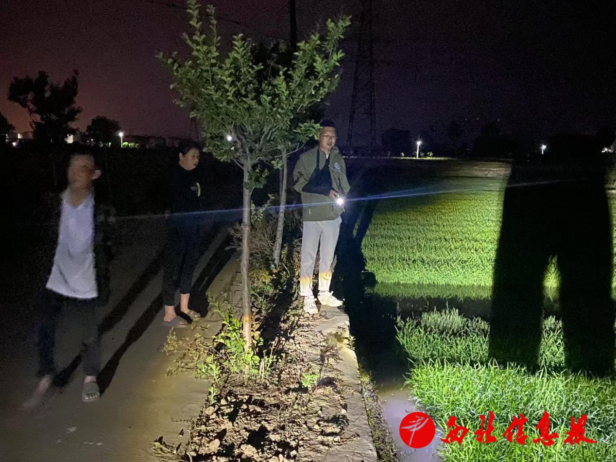 旱情不除，职工不休。夜幕中，李辉（中）和放水员一起“撵水”，在田间组织抗旱灌溉。