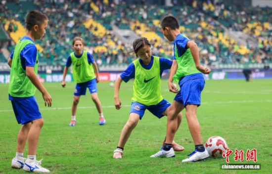 9月26日,参加本次足球梦想启航营活动的15名新疆足球少年走进北京工人体育场,观看中超联赛比赛。图为孩子们在比赛中场休息期间登场表演。(中足联 供图)