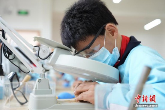 一名小学生正在清理“化石”上的泥土。刘鸿鹤 摄