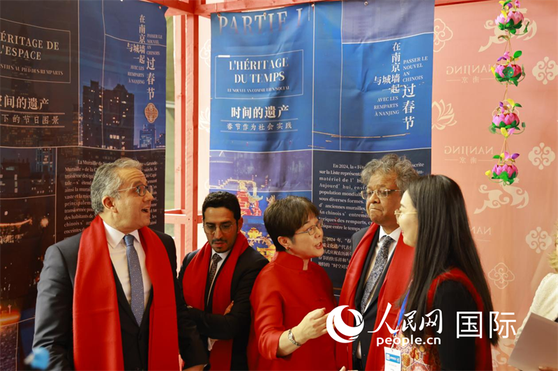 杨新育向联合国教科文组织高级别代表们介绍春节庙会上的南京符号展内容。人民网记者尚凯元摄