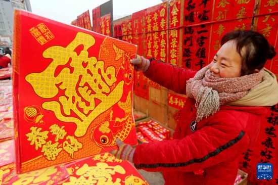 2月15日,市民在江苏省连云港市连云区一年货市场选购新春饰品。
