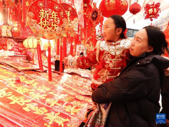 2月15日,市民在四川省达州市通川区珠市街年货大集选购春节饰品。