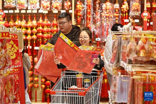 2月14日,在浙江省嘉兴市南湖区一家大型商场“年货一条街”,市民在选购福字。