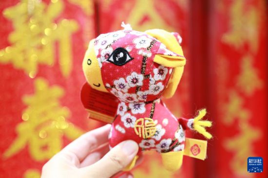 2月15日,人们在云南省蒙自市一商场展示选购的马造型饰品。