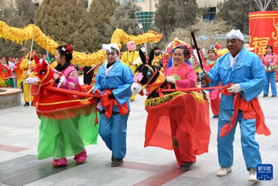 2月15日,一支社火队在甘肃省敦煌市城区市政广场表演社火跑驴。