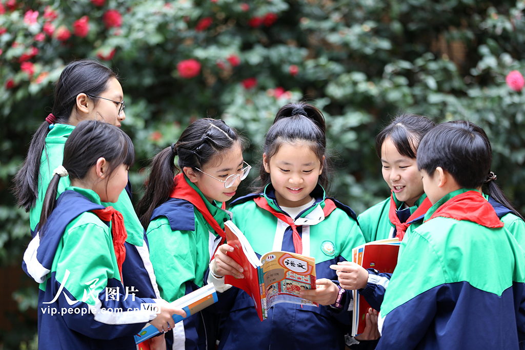 2026年3月1日，四川乐山市翡翠实验学校，学生们手持新领取的课本互相交流，以笑容迎接新学期的到来。李华时摄（人民图片网）