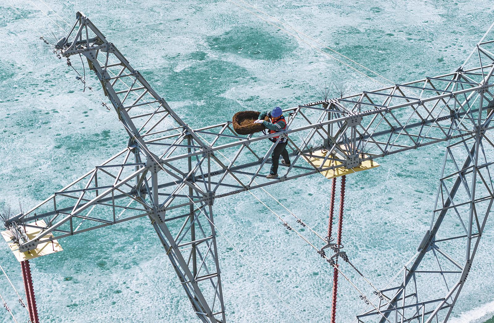 在位于新疆阿勒泰福海县的乌伦古湖国家湿地公园,国网阿勒泰供电公司工作人员在固定生态鸟巢(4月1日摄,无人机照片)。 地处额尔齐斯河流域的新疆阿勒泰,水系密布、生态优良,是候鸟迁徙、栖息繁衍的重要区域。随着近期气温回升,当地迎来候鸟迁徙高峰,鸟类活动增多也给输电线路安全运行带来压力。 为此,国网阿勒泰供电公司开展 “生命鸟巢” 专项行动,工作人员借助无人机,在湿地公园及环湖重点线路沿线精准投放安装生态鸟巢16处。通过主动为鸟类营造安全的栖息场所,有效避免鸟类在输电设施上筑巢引发安全隐患,实现生态保护与电力运维协同推进,助力区域生态与电力事业和谐共赢。 新华社发 努尔别克·努尔曼 摄