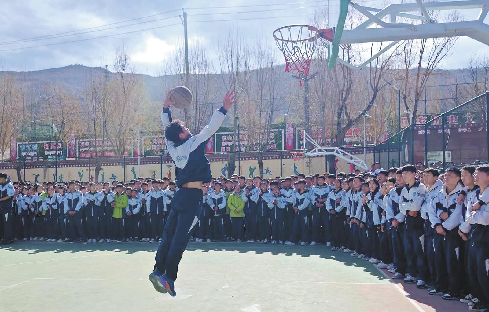 体育特色课堂,学生扣篮中。