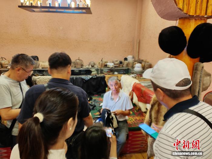 中亚媒体代表采访新疆沙雅县国家级非遗代表性传承人艾麦尔·吐尼亚孜。安冉 摄