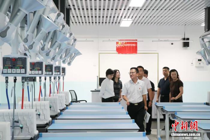 开学在即，新落成的乌鲁木齐市第十三中学高新校区将迎来首批七年级新生。图为学生家长参观教学设施。苟继鹏 摄