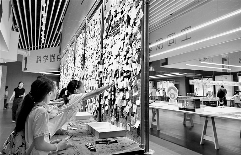 青少年在上海科技馆“从零到无穷 科技馆展品诞生记”展厅内设置的展品许愿墙前张贴自己写下的愿望。新华社发